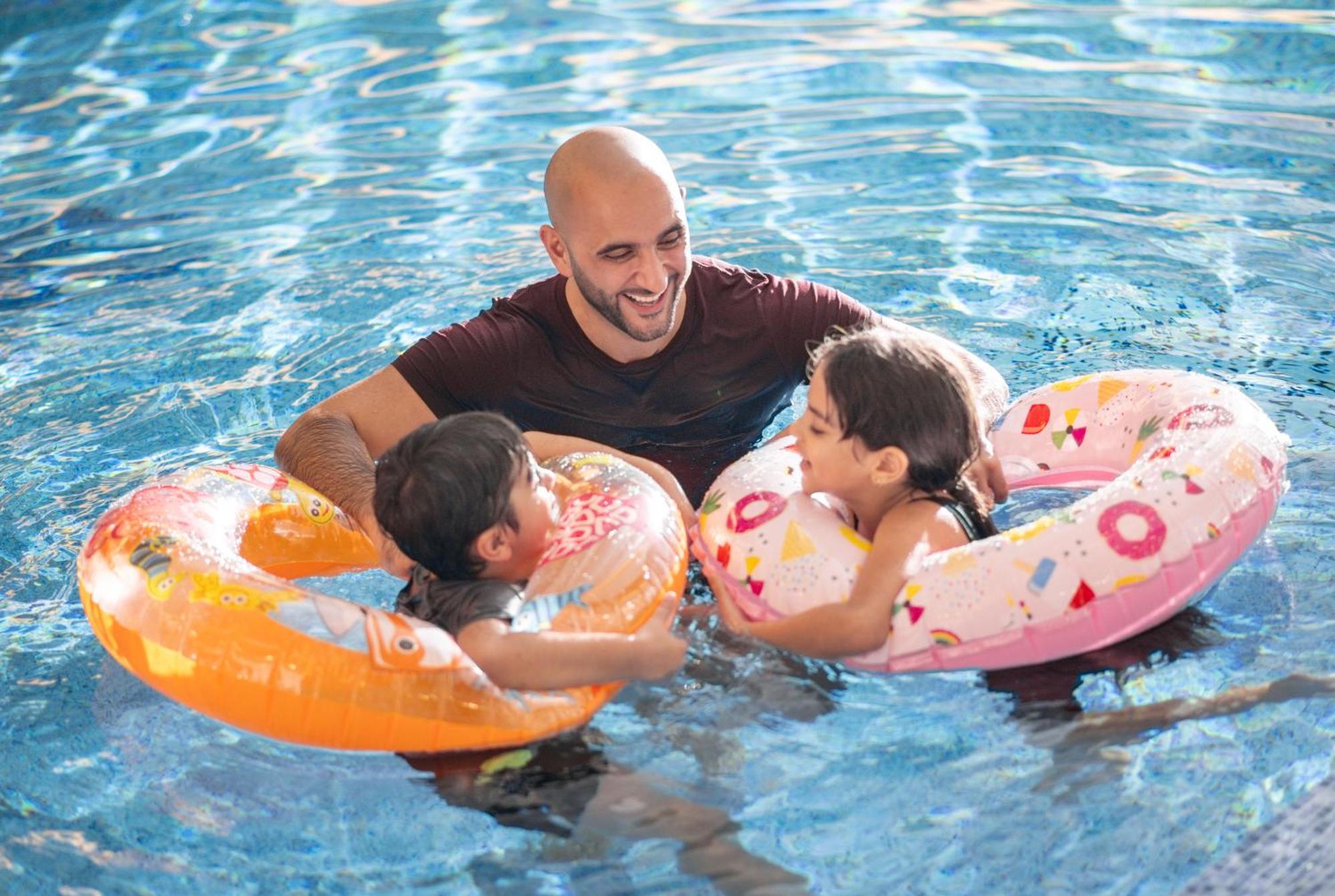 Delta Hotels By Marriott City Center 도하 외부 사진 A father and two children in a swimming pool